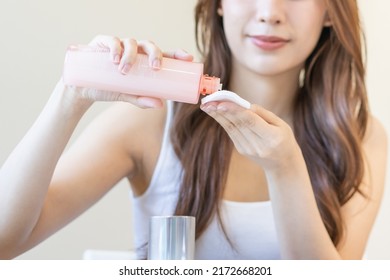Happy beauty, attractive asian young woman hand in holding cotton pad, applying cleansing, lotion facial wipe on her face, removing makeup before shower in bathroom, skin care on white background. - Shutterstock ID 2172668201