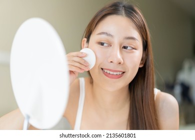 Happy Beauty, Beautiful Asian Young Woman, Girl Looking In To Mirror, Holding Cotton Pad, Applying Facial Wipe On Her Face, Removing Makeup Before Shower In Bathroom, Skin Care On White Background.