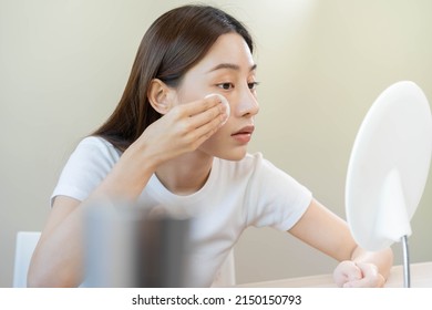 Happy Beauty, Beautiful Asian Young Woman, Girl Looking In To Mirror, Holding Cotton Pad, Applying Facial Wipe On Her Face, Removing Makeup Before Shower In Bathroom, Skin Care On White Background.