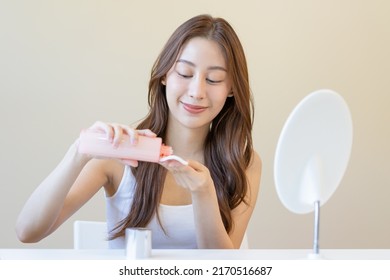 Happy Beauty, Beautiful Asian Young Woman, Girl Looking In To Mirror, Holding Cotton Pad, Applying Facial Wipe On Her Face, Removing Makeup Before Shower In Bathroom, Skin Care On White Background.