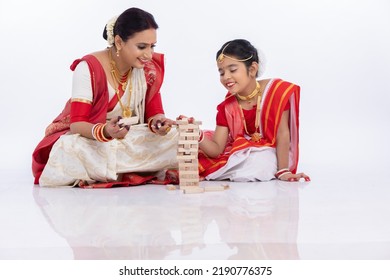 Happy Bengali Mother With Daughter Playing Wooden Blocks Together In Traditional Clothing
