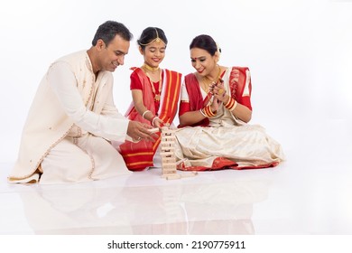 Happy Bengali Parents With Daughter Playing Wooden Blocks Together In Traditional Clothing
