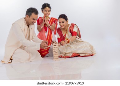 Happy Bengali Parents With Daughter Playing Wooden Blocks Together In Traditional Clothing
