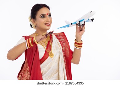 Happy Bengali Woman In Traditional Sari Flying Toy Airplane
