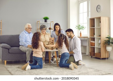 Happy big family gather together in their cozy modern living room. Little sisters playing board games with mom, dad, granny and granddad, talking, communicating, having fun, enjoying good time at home - Powered by Shutterstock