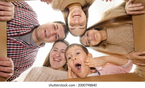 Happy Big Family Getting Surprised After Opening Big Cardboard Box And Looking Inside