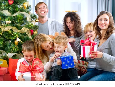 Happy Big Family Holding Christmas Presents At Home.Christmas Tree