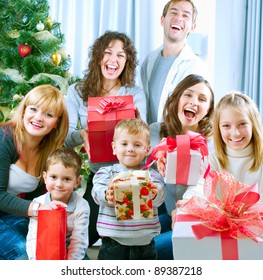 Happy Big Family Holding Christmas Presents At Home.Christmas Tree