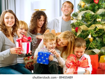 Happy Big Family Holding Christmas Presents At Home.Christmas Tree