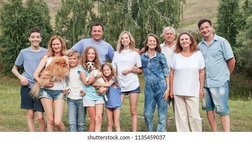 Happy big family outdoors. Mother, father, senior, children and dog outdoors.