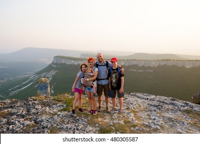 Happy big family travel together on top, peak of mountain. Traveler man and woman, father and mother with children on vacation. Beautiful nature landscape tourism, hiking. Parents with kids outdoors.