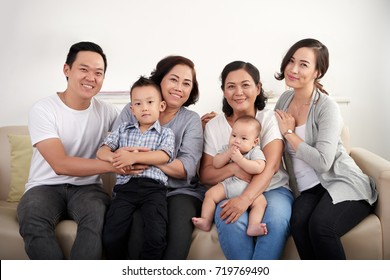 Happy Big Vietnamese Family Sitting On Sofa