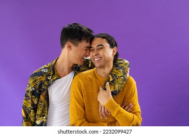 Happy biracial couple embracing with eyes closed and smiling on purple background. Lgbt and pride concept. - Powered by Shutterstock