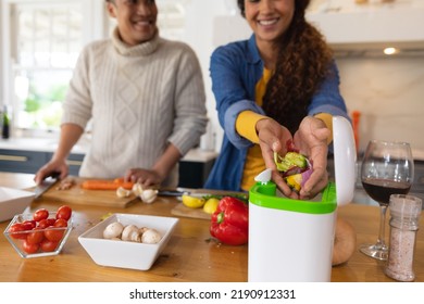 Happy biracial couple preparing food and composting vegetable waste in kitchen. Inclusivity, domestic life, leisure time, togetherness and eco awareness concept. - Powered by Shutterstock