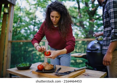 Happy Biracial Couple Resting And Preparing Burgers Outdoors In A Tree House, Weekend Away