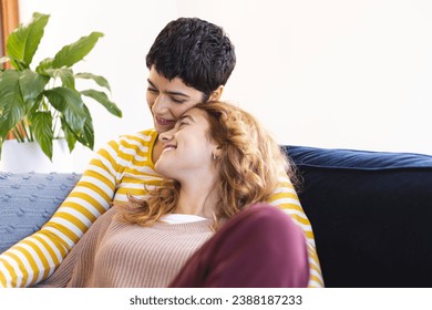 Happy biracial lesbian couple relaxing on couch together embracing at home, copy space. Gay, love, relationship, togetherness, domestic life and lifestyle, unaltered. - Powered by Shutterstock