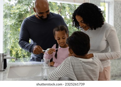 Happy biracial parents, son and daughter brushing teeth together in bathroom in the morning. Family, togetherness, self care, hygiene, healthy living and domestic life, unaltered. - Powered by Shutterstock