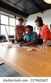 Happy Biracial Photographer Discussing With Multiracial Colleagues In Meeting At Office. Unaltered, Creative Business, Meeting, Teamwork, Diversity, Photography Themes.