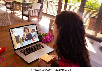 Happy biracial young couple dating on video call through laptop during valentine day. unaltered, online dating, video call, wireless technology and distant valentine day celebration. - Powered by Shutterstock