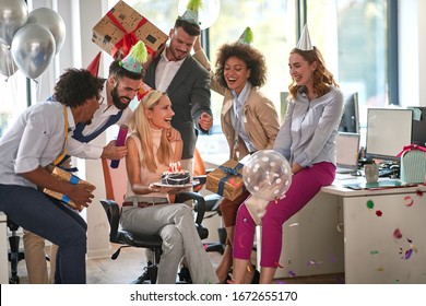 Happy birthday from all of us. Mixed race happy young coworkers celebrating a birthday of colleague in the modern office - Powered by Shutterstock