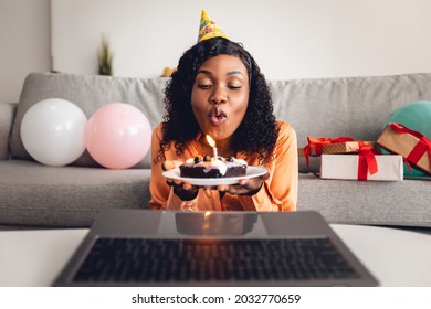 Happy Birthday. Black Lady Blowing Candle On Cake In Front Of Laptop Computer Celebrating Her Holiday Remotely, Having Virtual Party Via Video Call At Home. Modern B-Day Celebration - Powered by Shutterstock