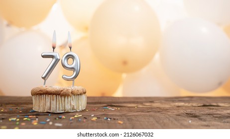 Happy birthday card with candle number 79 in a cupcake against the background of balloons. Copy space happy birthday for seventy nine years old