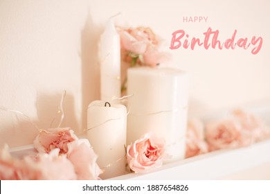 Happy Birthday Card With Greeting Text. Decoration Of  Room For Birthday Celebration. Closeup Of Tender Light Pastel Pink Roses And White Candles On Shelf For Themed Party. 