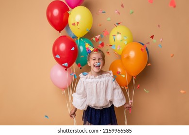 Happy Birthday party. Child girl with balloons on beige background.