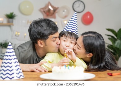 Happy Birthday Party In Family, Asian Young Parent Father, Mother And Little Cute Boy Or Child Celebrating, Blowing Candles On The Cake And Decorated Balloons, Celebration At Home. Lovely Moments