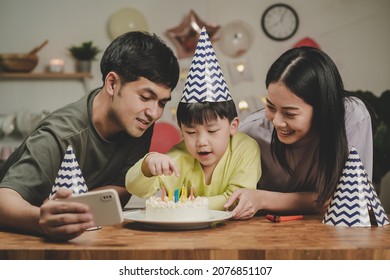 Happy Birthday Party In Family, Asian Young Parent Father, Mother And Little Cute Boy Or Child Celebrating, Blowing Candles On The Cake And Decorated Balloons, Celebration At Home. Lovely Moments