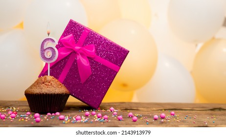 Happy birthday with pink gift box for 6 year old girl. Beautiful birthday card with cupcake and number six burning candle.
