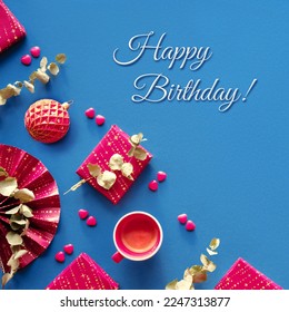 Happy birthday in wintertime, December, January, February. Magenta gift boxes, paper fan, eucalyptus, sugar hearts. Square geometric corner composition, flat lay on dark blue textile linen background. - Powered by Shutterstock