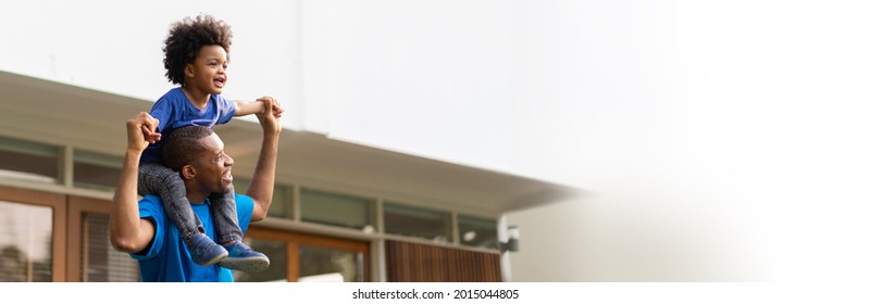 Happy Black African American Brazilian Father carrying his little boy playing together outdoor. Family Having fun on holiday. Panoramic, Banner. - Powered by Shutterstock