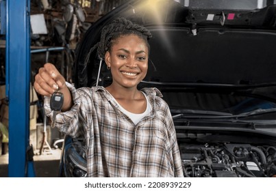 Happy Black African Female Car Owner Showing Car Key After Fixing Vehicle With Good Service In Car Repair Shop, Black Woman Car Owner Smiling And Satisfied With Automobile Maintenance Garage Service