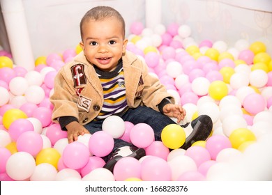Happy black boy in colored ball on birthday on playground  The concept of childhood and holiday