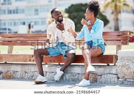 Happy black couple eating ice cream on a beach bench together, smiling while bonding and laughing. Young African American man and woman enjoying their summer romance, free time and relationship