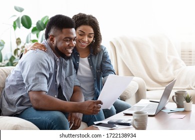 Happy Black Couple Managing Family Budget At Home Together, Checking Utility Bills, Copy Space