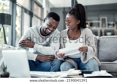 Happy black couple paying bills on a laptop at home, checking their budget and savings. Smiling African american husband and wife enjoying future planning, excited about an investment and good