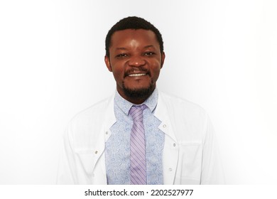 Happy Black Doctor Man With Small Beard In White Coat Bright Shirt Isolated On White Background. Smiling Adult Black African American Physician Therapist Portrait, Pleasant Excited Candid Male Emotion