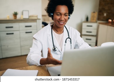 Happy Black Doctor Using Computer While Having Video Call In Her Office. 