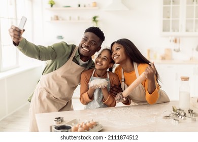 Happy Black Family Baking And Making Selfie On Cellphone Hugging Posing Together Standing In Modern Kitchen Indoors. Weekend Leisure, Gadgets Lifestyle Concept - Powered by Shutterstock