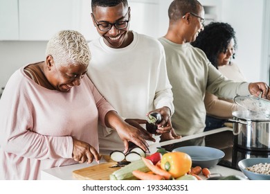 Happy Black Family Cooking Inside Kitchen At Home - Father, Daughter, Son And Mother Having Fun Preparing Lunch - Main Focus On Boy Face