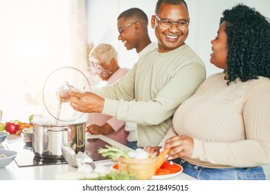 Happy Black Family Cooking Inside Kitchen At Home - Focus On Father Face