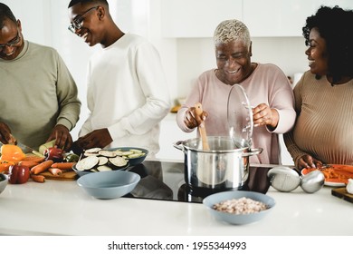 Happy Black Family Cooking Vegan Food Inside Kitchen At Home - Focus On Mother Face