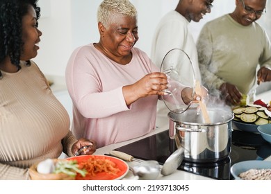 Happy Black Family Cooking Vegan Food Inside Kitchen At Home - Focus On Mother Face