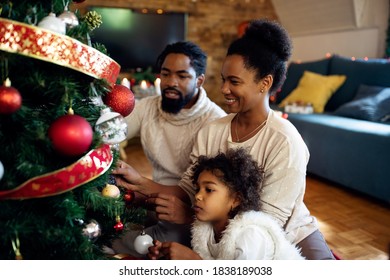 Happy Black Family Decorating Christmas Tree At Home. Focus Is On Mother. 