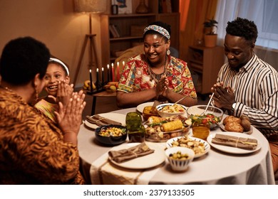 Happy Black family enjoying traditional Kwanzaa dinner at home - Powered by Shutterstock