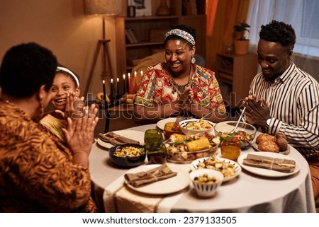 Happy Black family enjoying traditional Kwanzaa dinner at home