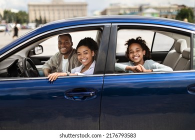 Happy Black Family In New Blue Car Posing Smiling To Camera Having Ride In City. Parents And Preteen Daughter Sitting In Luxury Auto. Automobile Ownership And Purchase Concept. Selective Focus