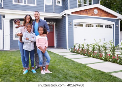 Happy black family standing outside their house